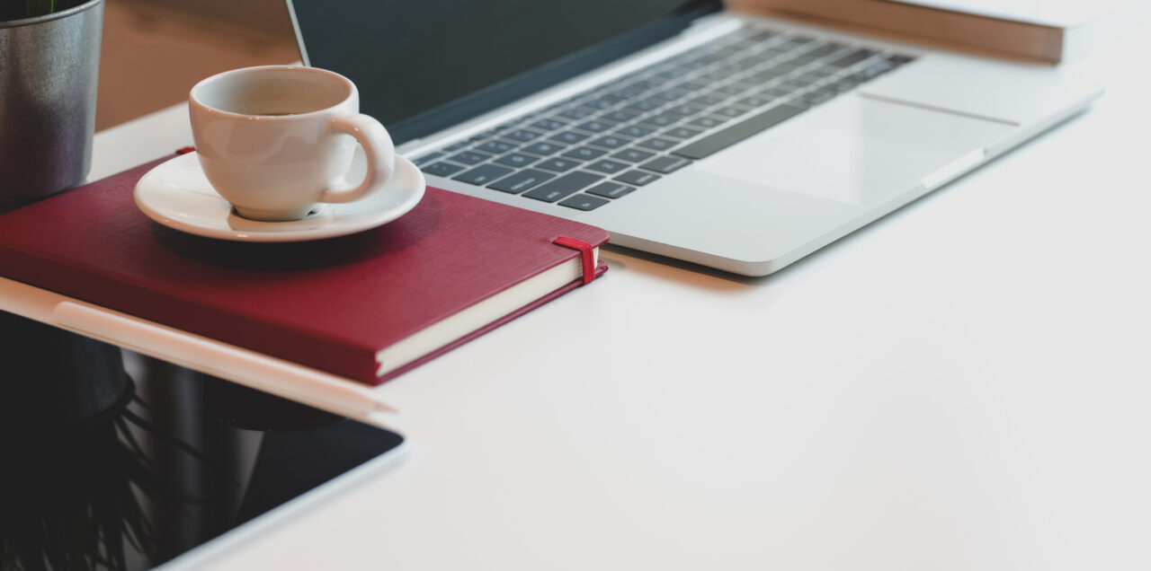 Coffee mug on a red book next to a laptop at our boutique hotel in Tampa, FL