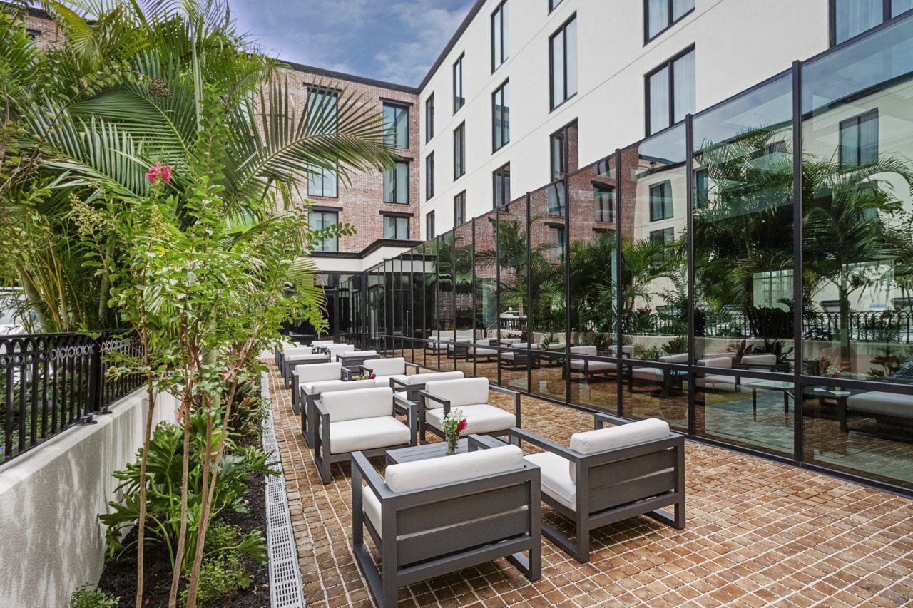 Modern steel lounge chairs and large plants on a patio at our Ybor City hotel
