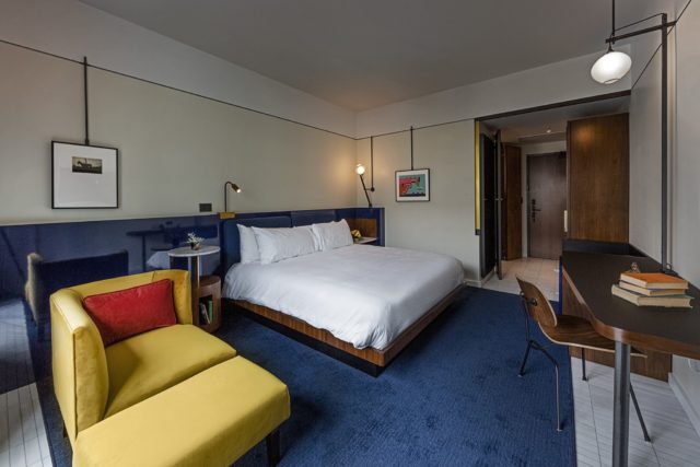 King bed, blue carpet, and yellow sofa at our hotel near Ybor City