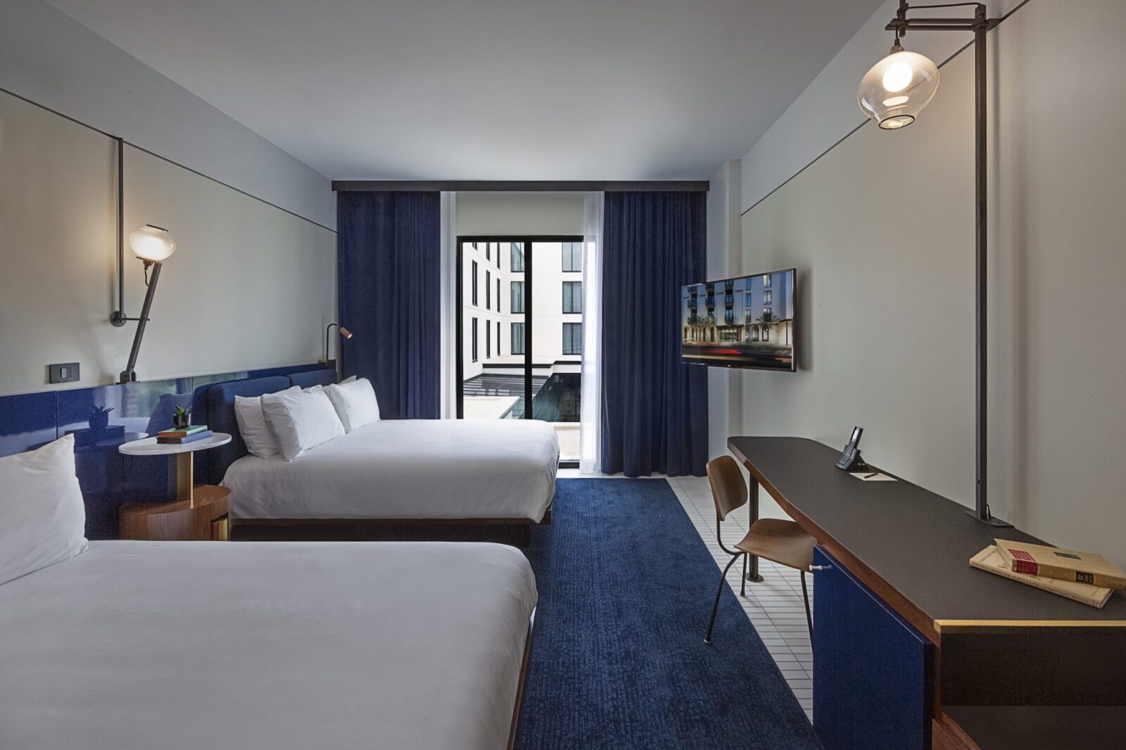 2 beds in a room with a balcony at our hotel in Ybor City, Tampa