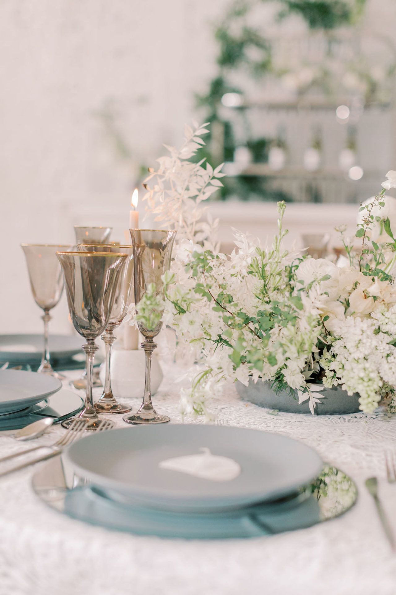 Beautiful white covered table, white center piece and blue plates at our Tampa event venue