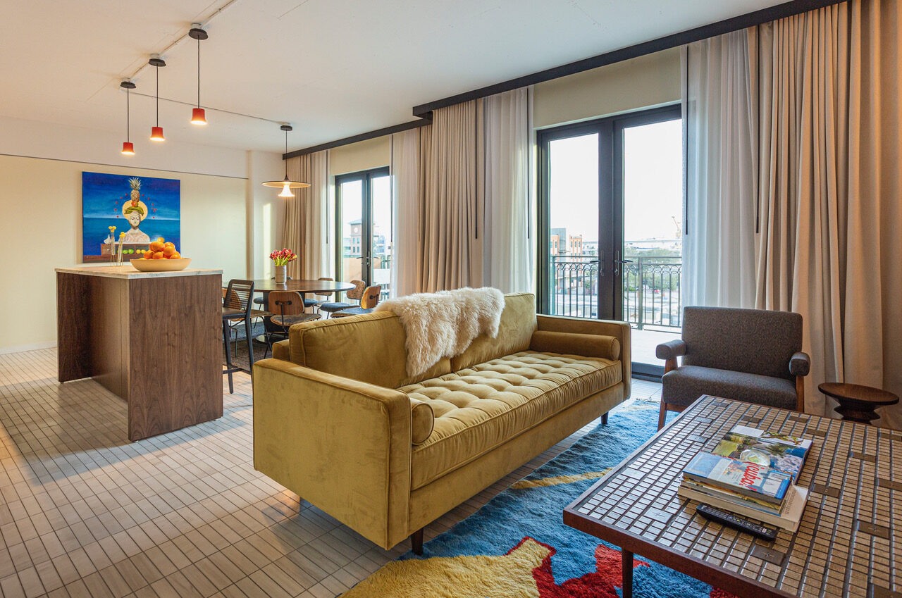 Sofa and dining table with balcony outside the doors with Tampa city views at Hotel Haya