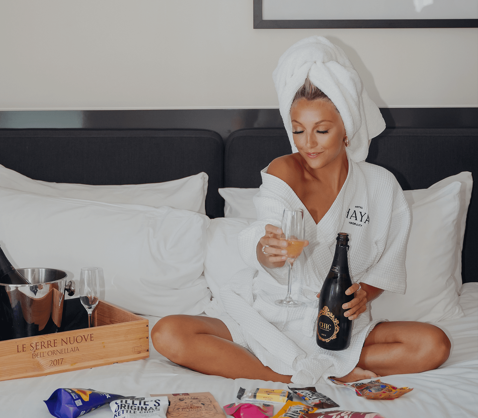 Woman on bed with bottle of champagne
